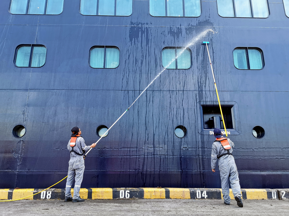 Photo of Two Men Cleaning Ship